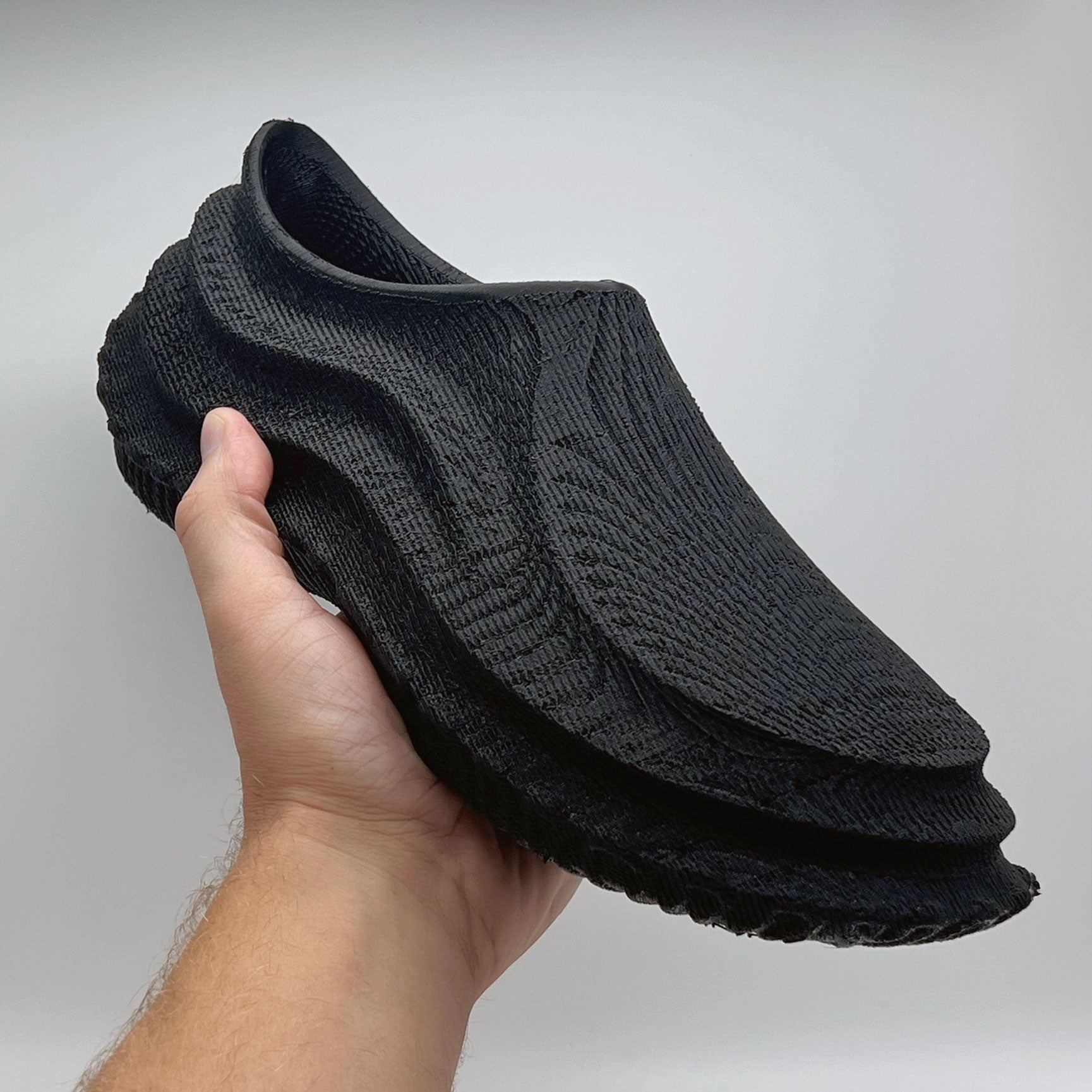 3D printed shoes in hand with techno graphite color